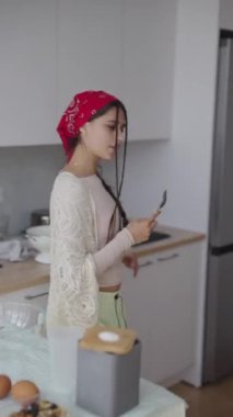 Genç ve hayat dolu bir içerik yaratıcısı, güzel, parlak bir mutfakta yetenekli ve eğlenceli bir şekilde yemek pişirmekten zevk alır.