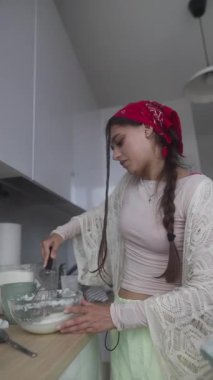 Genç bir kadın şık bir mutfakta ustalıkla mutfak sanatlarına olan tutkusunu benimsiyor.