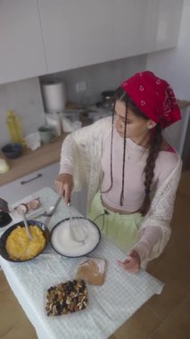 Bir kadın, modern bir mutfakta lezzetli ve lezzetli bir yemek hazırlar. Canlı, taze malzemeler sergiler.