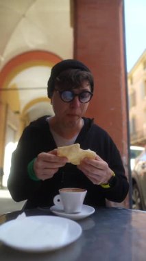 Kafede kahve ve ekmekle geçen bir an, hayat dolu bir atmosferde günlük hayatı yakalıyor.