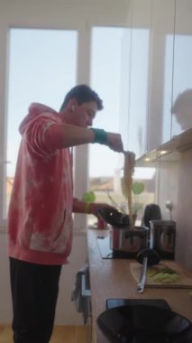 Doğal ışıkla dolu parlak ve havadar bir mutfakta, genç bir şef ustalıkla ağız sulandırıcı yemekler hazırlar.