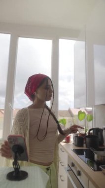 Bir insan, aydınlık ve çağdaş bir mutfak ortamında çeşitli yemek pişirme faaliyetleriyle derinden ilgilidir.