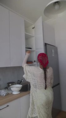 Genç bir kadın, parlak renklerle dolu şık ve modern bir mutfakta tutkuyla lezzetli yemekler hazırlıyor.