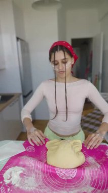 Canlı bir mutfakta, genç bir kadın mangırı tutkuyla yoğurur, yeteneklerini göstererek