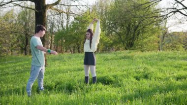 Canlı ve canlı bir açık hava sahnesi, çimenlerin yemyeşil bir tarlasında neşe içinde arkadaşlarıyla etkileşim halindedir.