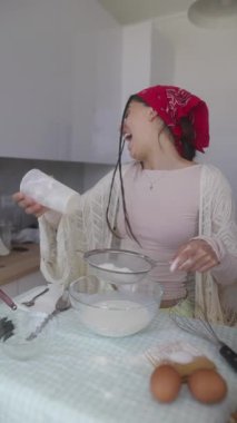 Hayat dolu genç bir kadın, mutfağında lezzetli yemekler pişiriyor. Malzemeleri özenle ve sevgiyle karıştırıyor.