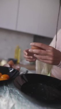Güzel tasarlanmış bir mutfak ortamında yumurtaları ustalıkla kıran ellerin büyüleyici ve göz kamaştırıcı görüntüleri.