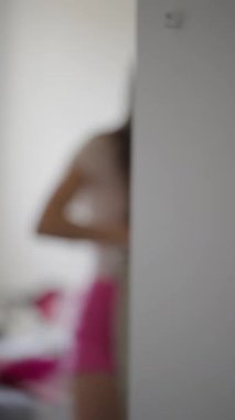 Genç bir kadın şık dekore edilmiş yatak odasında çamaşırlarını düzenliyor, benzersiz hayat tarzını ve yaşam tarzını sergiliyor.