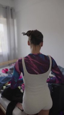 Bir kadın rengarenk giysiler içinde bir elbise koleksiyonu topluyor, etkin bir şekilde güzel bir yer gösteriyor.