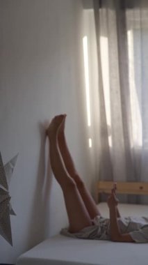 Uzun ve stresli bir günden sonra gevşemek için ideal bacaklarının duvara yaslandığı rahatlatıcı bir sahne hayal et.