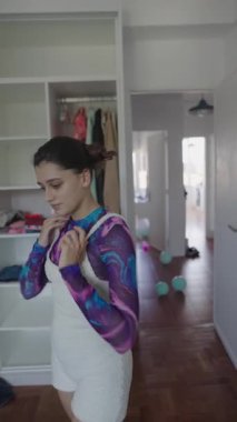 Kendine güvenen bir model şık ve şık bir ev ortamında canlı ve göz alıcı bir kıyafet sergiliyor.