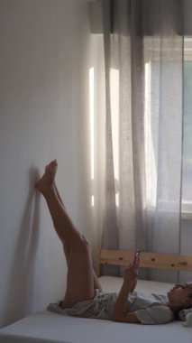 Rastgele ve sakin bir şekilde telefonunuzu kullanırken bacaklarınızı duvara dayayarak rahatlayın.