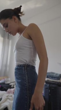 Genç bir kadın çeşitli moda kıyafetlerini denerken etkileyici tarzını sergiliyor.