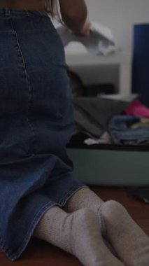 Şık bir genç kadın rahat ve rahat bir ortamda şık bir kot etek ve şık çoraplar sergiliyor.