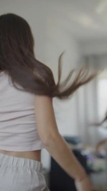 Genç bir kadın kendi stilini çizer, kişisel dokunuşlarla dolu parlak bir odada şık bir kıyafet sergiler..