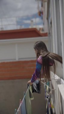 Renkli kıyafetlerle dolu şehir hayatının bir anlık görüntüsü. Bir hatta kuruyor, günlük ev işlerinin özünü yakalıyor..