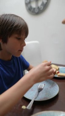 Keyifli bir çocuk evlerinin konforunda nefis bir yemeğin tadını çıkarıyor, yemeğin gerçek neşesini yakalıyor.