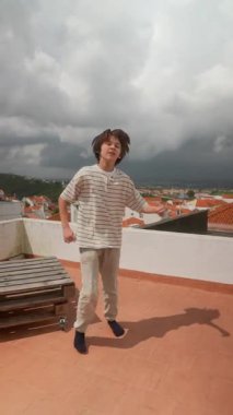 Dinamik bir çatı dansı performansı dışavurumcu hareketler ve oyuncu enerji patlamaları sergiliyor