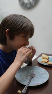 Lezzetli kahvaltının tadını çıkaran genç bir çocuk neşeli bir gülümsemeyle, günün keyifli bir anını yakalıyor.