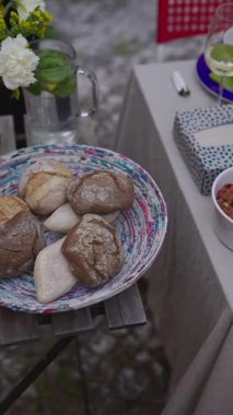 Şarap ve çiçeklerle birlikte güzel düzenlenmiş bir tabak zanaatkar ekmeği. Toplamak için mükemmel..