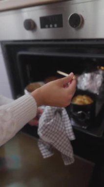 Bir el nazikçe fırının içine uzanır ve yeni pişmiş enfes kekleri şişle kontrol eder.