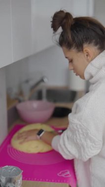 Yetenekli bir insan, modern bir mutfaktaki parlak, canlı pembe bir paspas üzerinde ustalıkla yumuşak hamur şekillendiriyor.