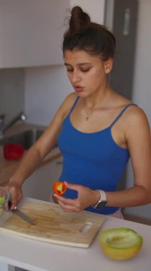 Parlak bir mutfakta, genç bir kadın taze sebzeleri ustalıkla doğrayarak sağlıklı yemekler hazırlıyor.