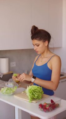 Bir kadın şık ve modern mutfağında lezzetli ve taze salataları ustalıkla hazırlar.