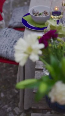 Şarabın, çeşitli tabakların ve çarpıcı çiçeklerin sergilendiği nefis bir açık hava yemek masası.