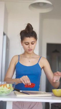 Şık bir mutfakta, genç bir kadın taze sebzeler hazırlar, sağlıklı yemek yapma sanatını benimser.