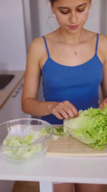Bir insan lezzetli salatalar için taze, canlı marul hazırlar. Mükemmel sağlıklı yemek yapma alışkanlıkları sergiler.