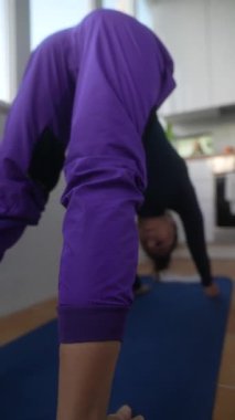 Parlak ve güneşli bir odada yoga yapan bir insan esneklik ve refahı sağlamaya odaklanır.