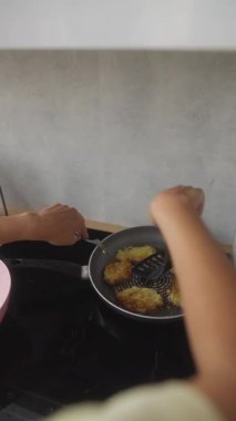 Fırının üstünde tavada çıtır kraker kızartan bir insan nefis bir yemek pişirme süreci sergiliyor..