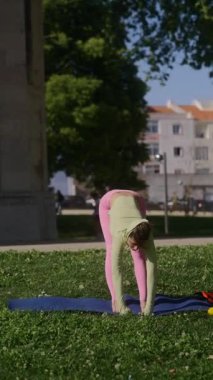 Bir kadın dışarıda yoga yapıyor. Esnekliğini ve gücünü huzurlu ve huzurlu bir ortamda sergiliyor.