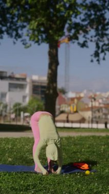 Bir insan dışarıda yoga yapıyor, doğanın ortasındayken esnekliğini ve farkındalığını gösteriyor.