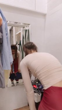 Soyunma odasında rengarenk kıyafetler deneyen genç bir kız stili ve özgüveni gözler önüne seriliyor.