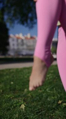 Açık hava ortamında açık renk bir bluzla eşleştirilmiş pembe taytlı canlı bir hareket gösterisi..