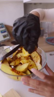 Nefis baharatlı patates dilimlerinin detaylı hazırlıklarını gösteren baştan çıkarıcı bir mutfak sahnesi.