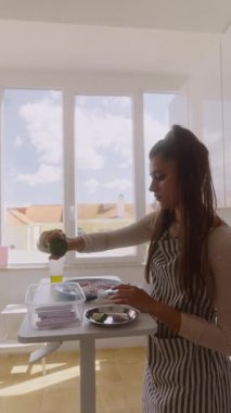 Bir kadın parlak bir mutfakta malzemelerini ustalıkla hazırlar. Mutfak yeteneklerini ve canlı renklerini sergiler.