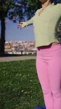 Bir insan açık havada canlı giysiler içinde yoga yapar, güzellikte sağlık ve uygunluğu teşvik eder.