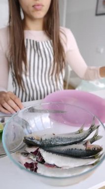 Yetenekli genç bir şef usta bir şekilde balık kesiyor, güzel bir şekilde deniz ürünleri pişirme sanatını sergiliyor.