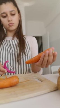 Parlak ve neşeli bir mutfak ortamında, odaklanmış bir birey ustalıkla ve ustalıkla taze havuç soyarlar.