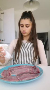 Kendini işine adamış genç bir kadın, parlak ve misafirperver bir mutfak ortamında balığı dikkatlice temizleyip hazırlıyor.