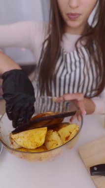 Eldiven giyen bir insan, çeşitli taze malzemeler kullanarak canlı ve renkli bir sebze yemeği hazırlar.