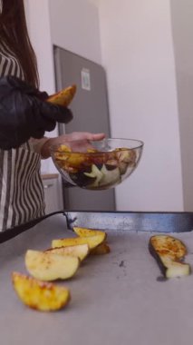 Modern ve şık bir mutfak ortamında, yetenekli bir şef fırında taze sebzeler hazırlıyor.