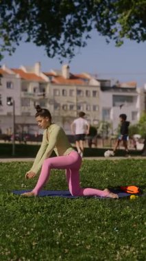 Bir kadın güneşli bir parkta çeşitli yoga pozisyonları uyguluyor. Sağlık ve zindelik yolculuğunu destekliyor.