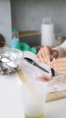 Yetenekli ellerin balıkları özenle hazırlayıp ev aşçıları için gerekli yemek tekniklerini sergilemesini izleyin..