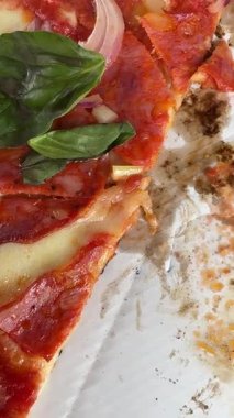 Lezzetli malzemeler ve taze fesleğenle kaplanmış taze yapılmış pizzaya bakın.