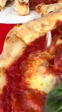 Lezzetli malzemeler ve taze fesleğenle kaplanmış taze yapılmış pizzaya bakın.