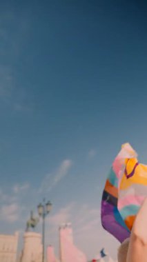 Parlak, güneşli bir zemine karşı renkli bayraklar sergilenen gurur ve kutlamanın canlı ve canlandırıcı bir gösterisi.